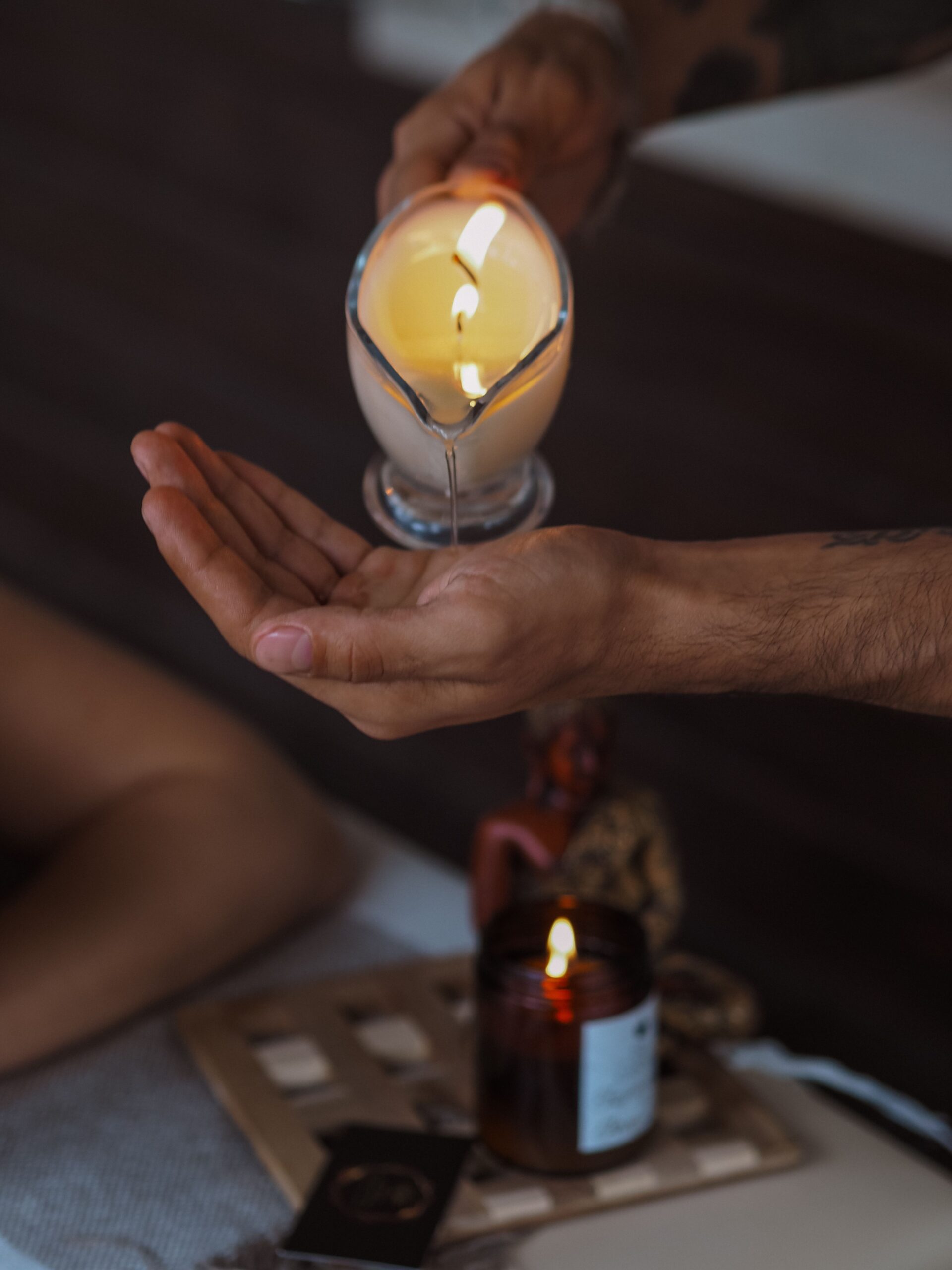 Serene indoor scene of candle massage oil being poured for spa treatment relaxation.
